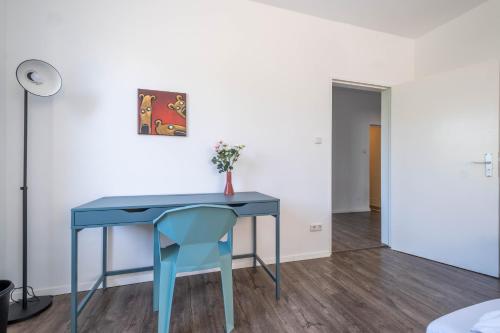 a blue table and a blue chair in a room at Spacious Flat in Karlsruhe