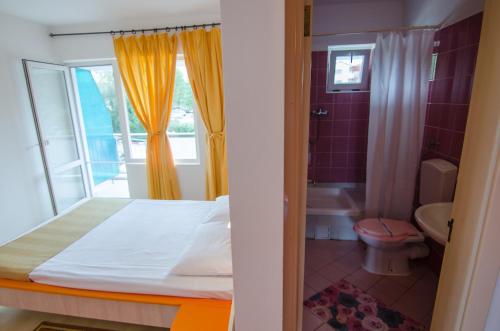 a bedroom with a bed and a bathroom with a window at COMPLEX MAJESTIC JUPITER All INCLUSIVE in Jupiter