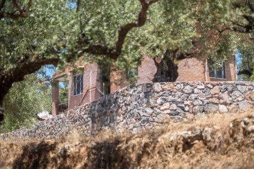 a stone wall in front of a brick house at Little country hut 'Mikri Eleni' in Akrogiali