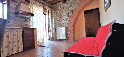 a kitchen with a red couch in a room at CAMPO AL VENTO - Country farm in Monte Castello di Vibio