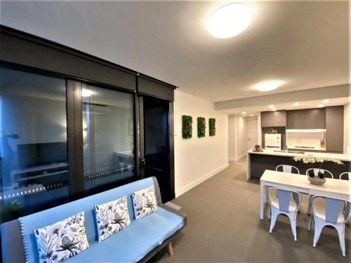 a living room with a blue couch and a table at Parkside & City view in Sydney Olympic Park in Sydney