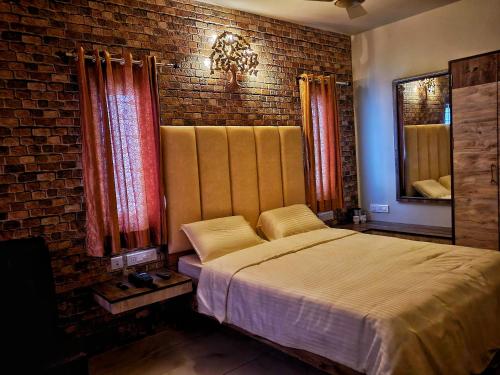 a bedroom with a bed and a brick wall at MM Resorts in Yercaud