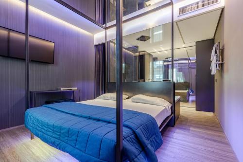 Schlafzimmer mit einem Bett mit blauer Decke in der Unterkunft Motel Rona in Caponago