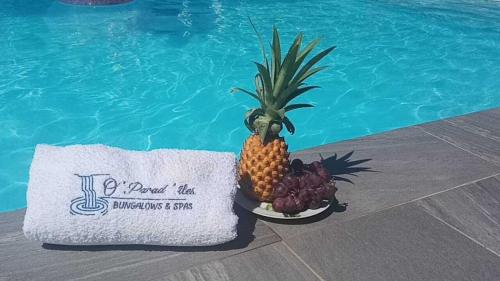 a pineapple sitting on a plate next to a swimming pool at O'Parad'îles in Goyave