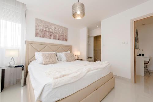 a white bedroom with a large bed with white sheets at URBAN LUXURY APARTMENT in Zadar