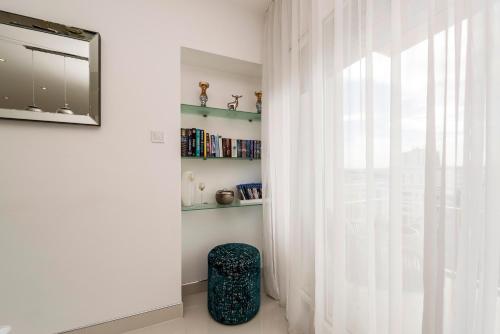 a room with white curtains and a chair next to a window at URBAN LUXURY APARTMENT in Zadar