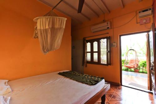 a bedroom with a bed and a window at Archana Guest House River View in Hampi