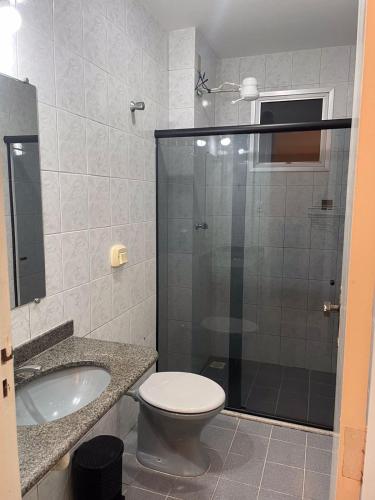 a bathroom with a shower and a toilet and a sink at Apartamento Praiana 303 in Guarapari