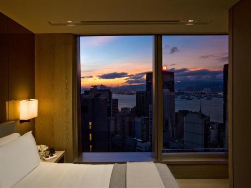 una camera da letto con una grande finestra con vista sulla città di One96 a Hong Kong