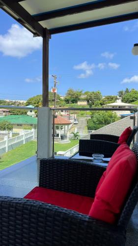 a porch with two black chairs and red pillows at Stonetrail in Arnos Vale