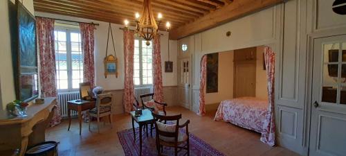 une chambre avec un lit, une table et des chaises dans l'établissement La Chanoinesse, à Salles-Arbuissonnas-en-Beaujolais