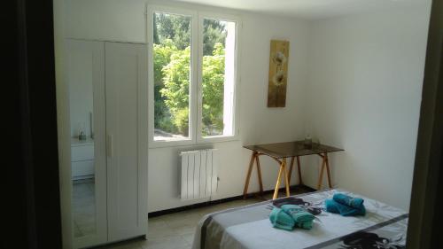 um quarto branco com uma cama e uma janela em LUBERON EN PROVENCE GITE 3 CHAMBRES 100 m2 avec PISCINE PRIVEE em Cheval-Blanc