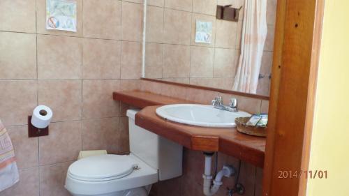 a bathroom with a toilet and a sink at Biohostal Mindo Cloud Forest in Mindo