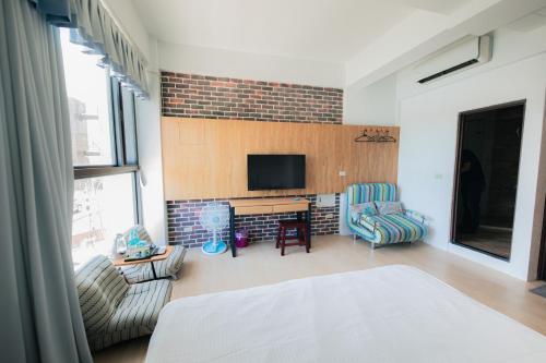 a living room with a bed and a tv at See Hualien B&B in Hualien City