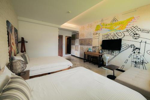 a room with two beds and a tv in it at See Hualien B&B in Hualien City