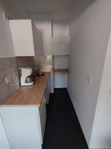 una pequeña cocina con armarios blancos y suelo negro en Aparthotel Siegen, en Siegen