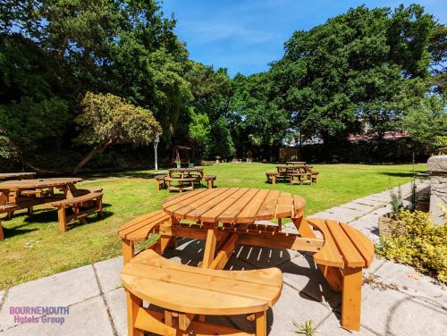 a wooden picnic table and benches in a park at The Grove Hotel in Bournemouth
