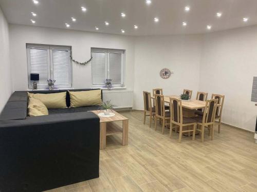 a living room with a couch and a table and chairs at Apartmán Levandule in Mařenice