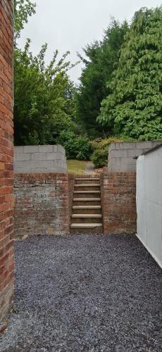 a brick wall with a set of stairs in a yard at Sparkling Space - Twin or King Beds in Bangor