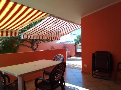 eine Terrasse mit einem Tisch und Stühlen unter Markise in der Unterkunft Casa Vacanze in Santa Caterina