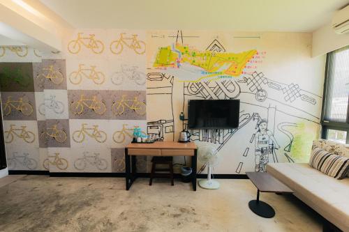 a living room with a mural of bikes on the wall at See Hualien B&B in Hualien City