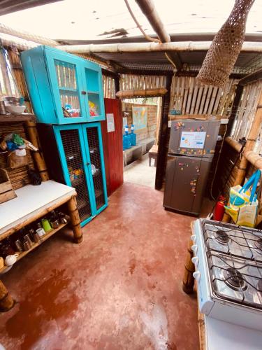 a kitchen with blue cabinets and a stove in a room at The Mudhouse Hostel Mompiche in Mompiche
