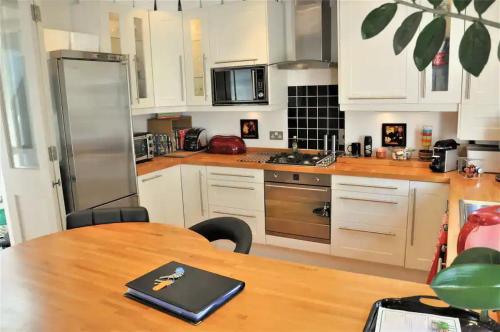 a kitchen with a table with a laptop on it at Sunny 2 bedroom, 2 bathroom Apartment with Roof Terrace in London
