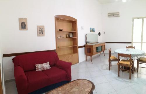 パルティニーコにあるDellangelo Casa Vacanzeのリビングルーム(赤いソファ、テーブル付)