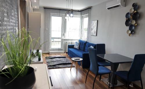 - un salon avec un canapé bleu et une table dans l'établissement Lively Debrecen, à Debrecen