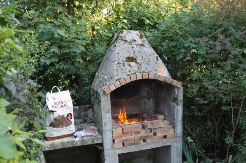 einen Steinofen mit einem Feuer darin in der Unterkunft Grand gîte de campagne capacité jusqu'à 10 personnes in Chantenay-Saint-Imbert