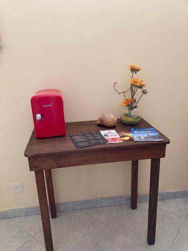 een houten tafel met een rode doos erop bij Casa Triscele Bis in Ispica