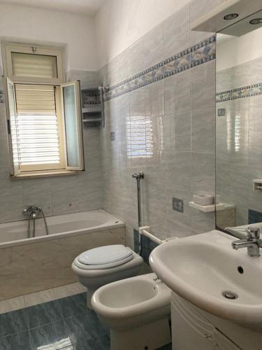 een badkamer met een wit toilet en een wastafel bij Casa Triscele Bis in Ispica