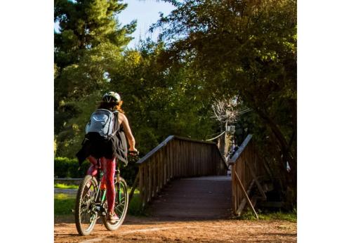 a woman riding a bike over a bridge at Little country hut 'Mikri Eleni' in Akrogiali