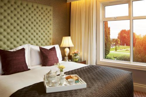 a bedroom with a bed with a tray of food on it at Lyrath Estate in Kilkenny