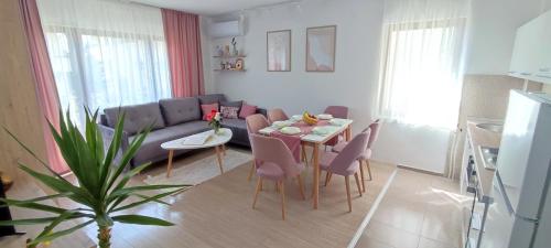 een woonkamer met een tafel en een bank bij Forest Apartments in Bitola