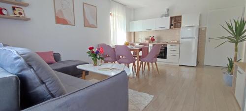 a living room with a couch and a table with pink chairs at Forest Apartments in Bitola
