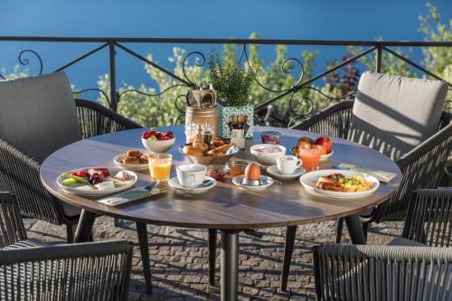 a table with plates of food on a patio at Parkhotel Brenscino Brissago in Brissago