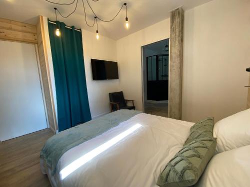 a bedroom with a large white bed and a window at La Parenthèse du Dahu Gîte de 6 pers in Métabief