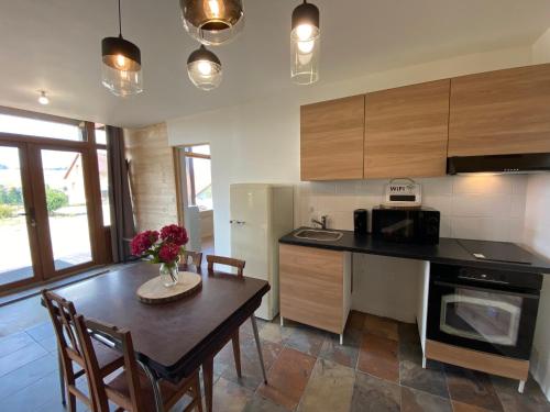 a kitchen with a wooden table and a dining room at La Parenthèse du Dahu Gîte de 6 pers in Métabief