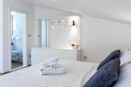 a bedroom with a white bed with towels on it at Apartments Ante 2 in Hvar