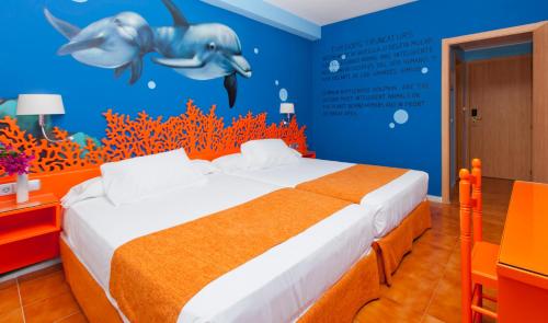 a bedroom with a bed with an orange and blue wall at Diver Aguadulce in Aguadulce