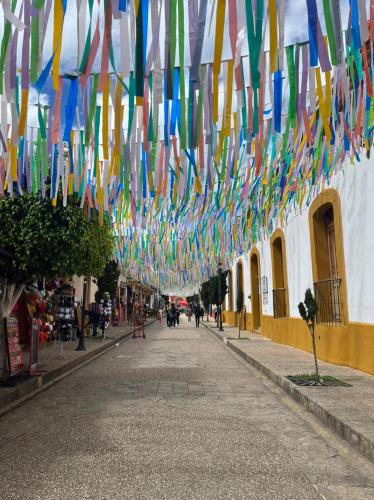 a row of colorful flags hanging over a street at Hostel Boutique 55 in San Cristóbal de Las Casas