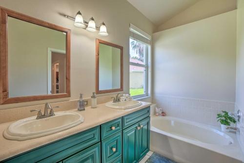 a bathroom with two sinks and a tub and a mirror at Sunny Brandon Getaway with Fire Pit! in Brandon