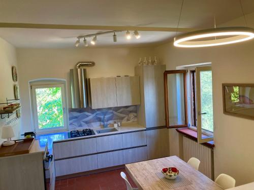 uma cozinha com uma mesa e um lavatório em Grove Cottage: Immersed in nature & close to town em Città della Pieve