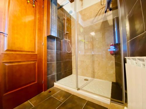 a shower with a glass door in a bathroom at Casa Forn in Pujal