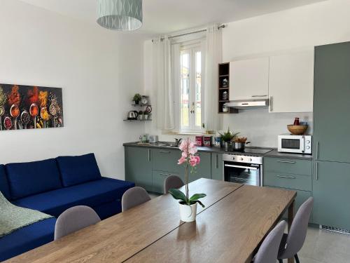 a kitchen and dining room with a table and a blue couch at Bnbook Cascina Crennese in Gallarate