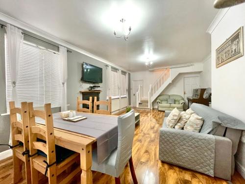a dining room and living room with a table and a couch at Penny Lein Apartments in Uxbridge