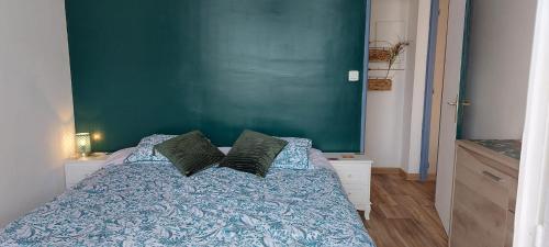 - une chambre dotée d'un lit avec un mur vert dans l'établissement Front de Mer et Grande Piscine pour un appartement chic et cosy, appartement en résidence à Canet en Roussillon, à 10 minutes de Perpignan, à Canet