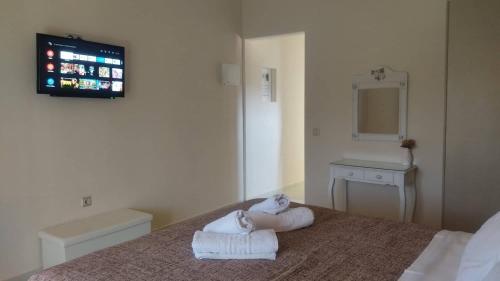 1 dormitorio con 1 cama con toallas en Kalliope Apartments, en Tsoukaladhes