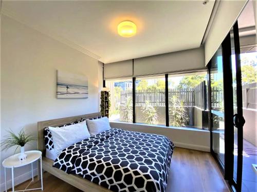 1 dormitorio con cama y ventana grande en Greenview in Sydney Olympic Park, en Sídney